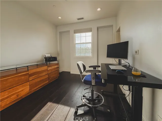 a work room with furniture a rug and a flat screen tv