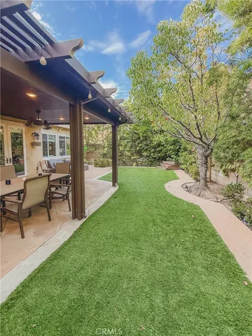 a view of a patio with table and chairs and floor to ceiling window