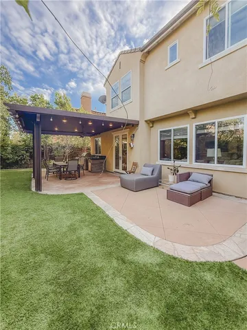 a view of a patio with table and chairs potted plants and large tree