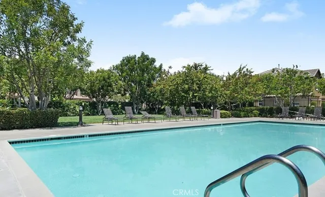 a view of a swimming pool and trees in the background