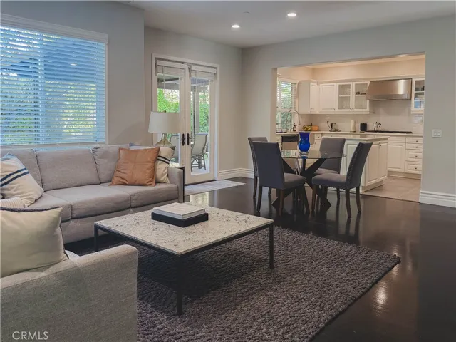 a living room with furniture and a dining table with wooden floor