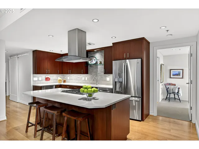 a kitchen with kitchen island a refrigerator stove and sink