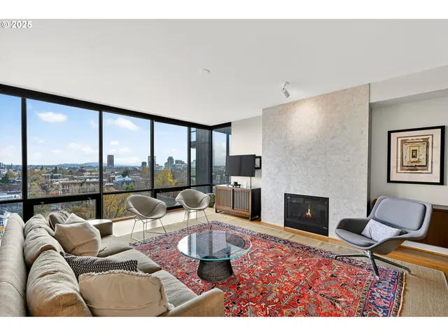 a living room with furniture large windows and a fireplace