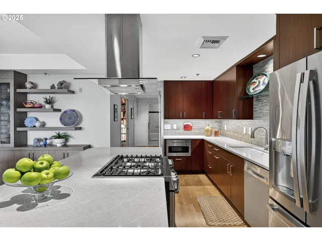 a kitchen with stainless steel appliances a stove a sink and a refrigerator
