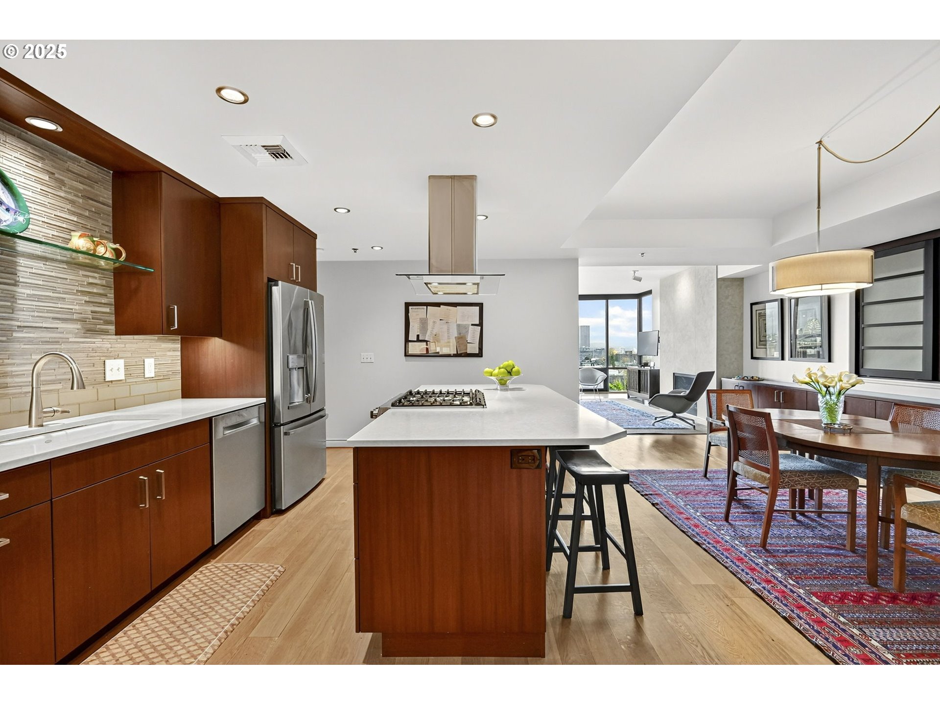 2448 Northwest Westover Road, Unit E402 Portland, OR 97210 - Photo 9 of 31 a open kitchen with stainless steel appliances kitchen island a dining table and chairs