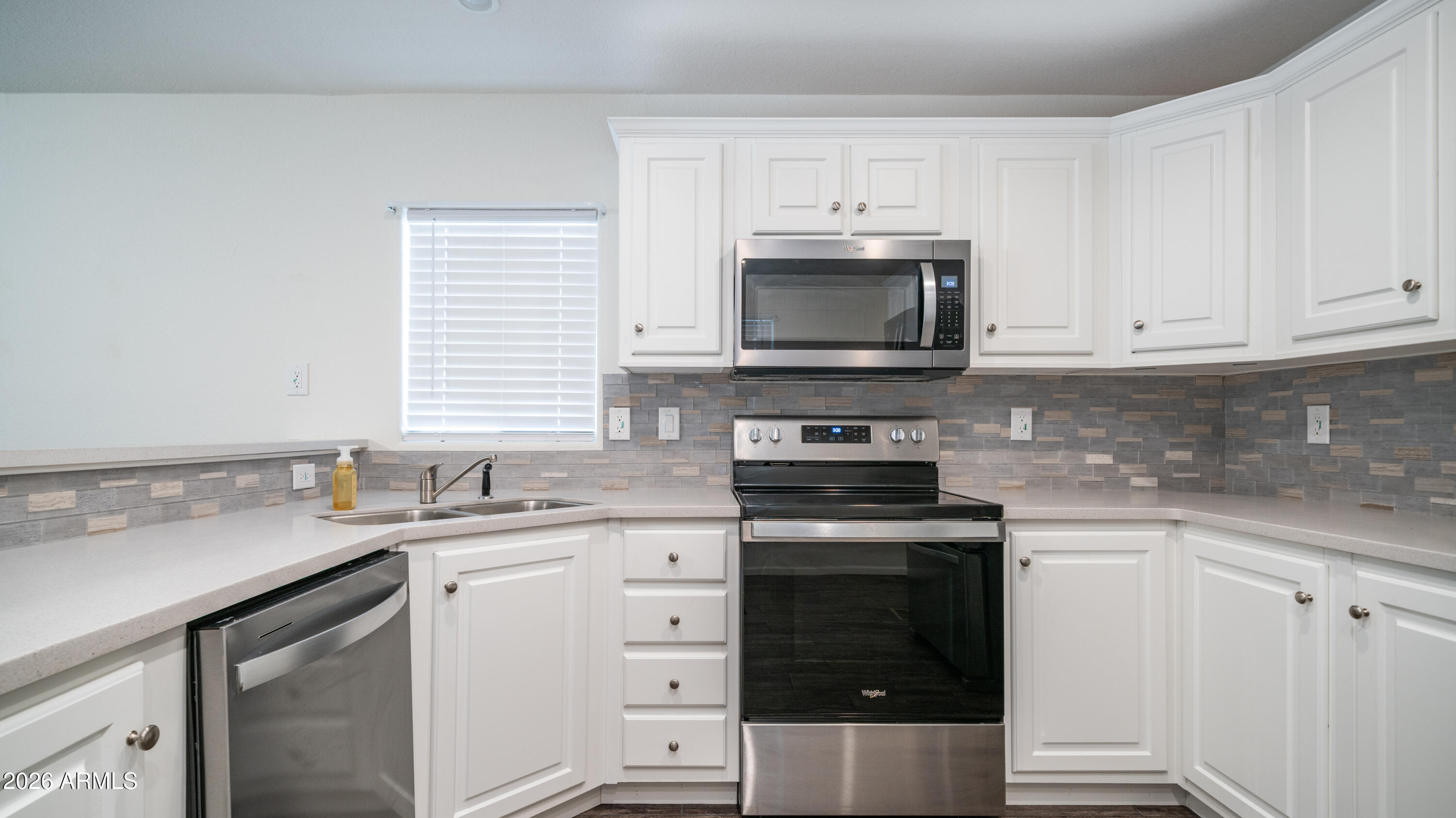 2929 East Main Street, Unit 237 Mesa, AZ 85213 - Photo 9 of 20 a kitchen with cabinets stainless steel appliances a sink and a stove
