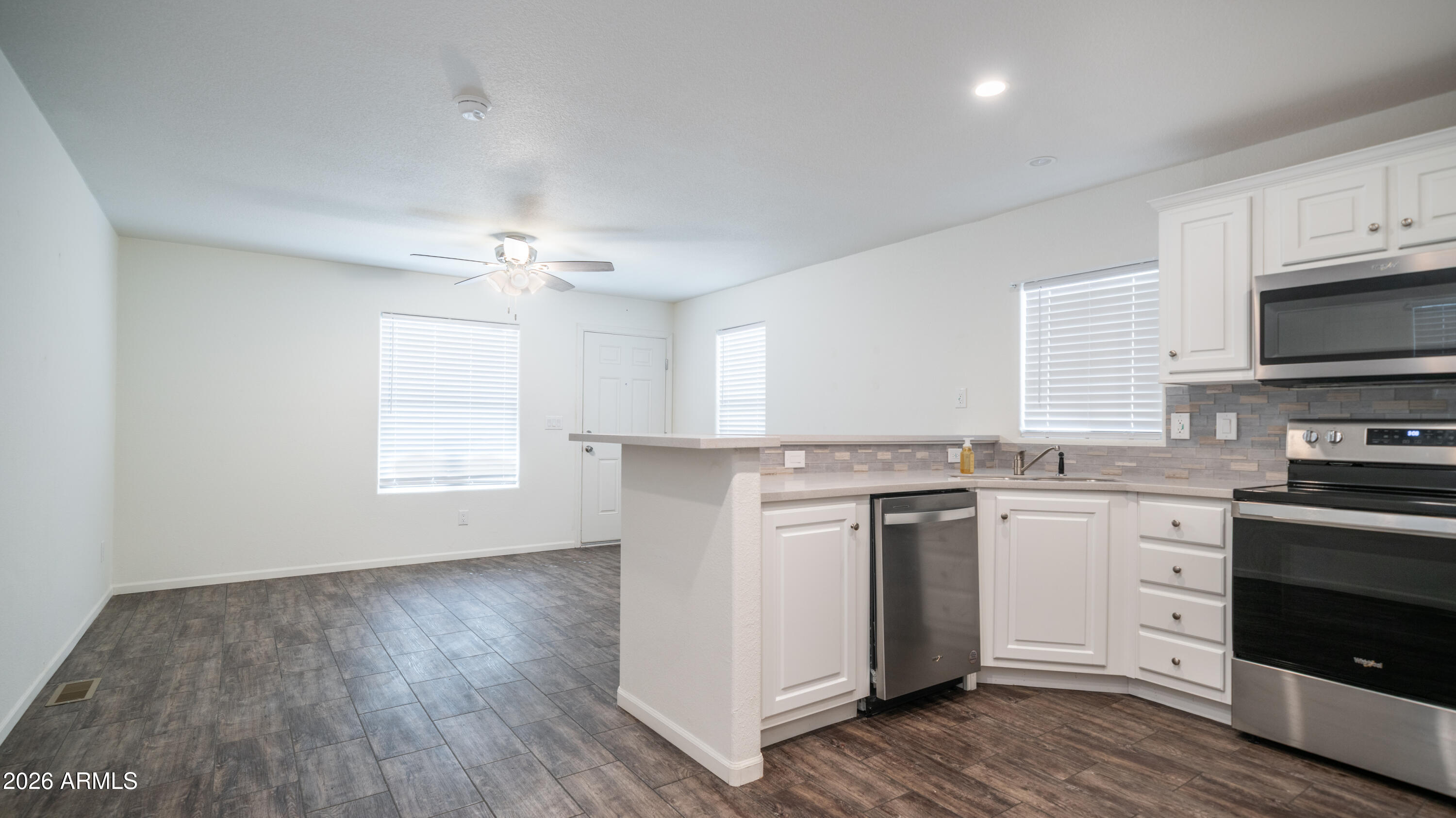 2929 East Main Street, Unit 237 Mesa, AZ 85213 - Photo 10 of 20 a kitchen with stainless steel appliances granite countertop a stove top oven a sink dishwasher and a refrigerator with wooden floor