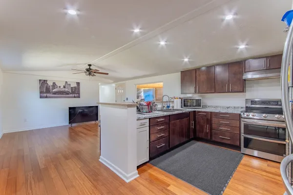a kitchen with stainless steel appliances granite countertop a refrigerator and a stove top oven