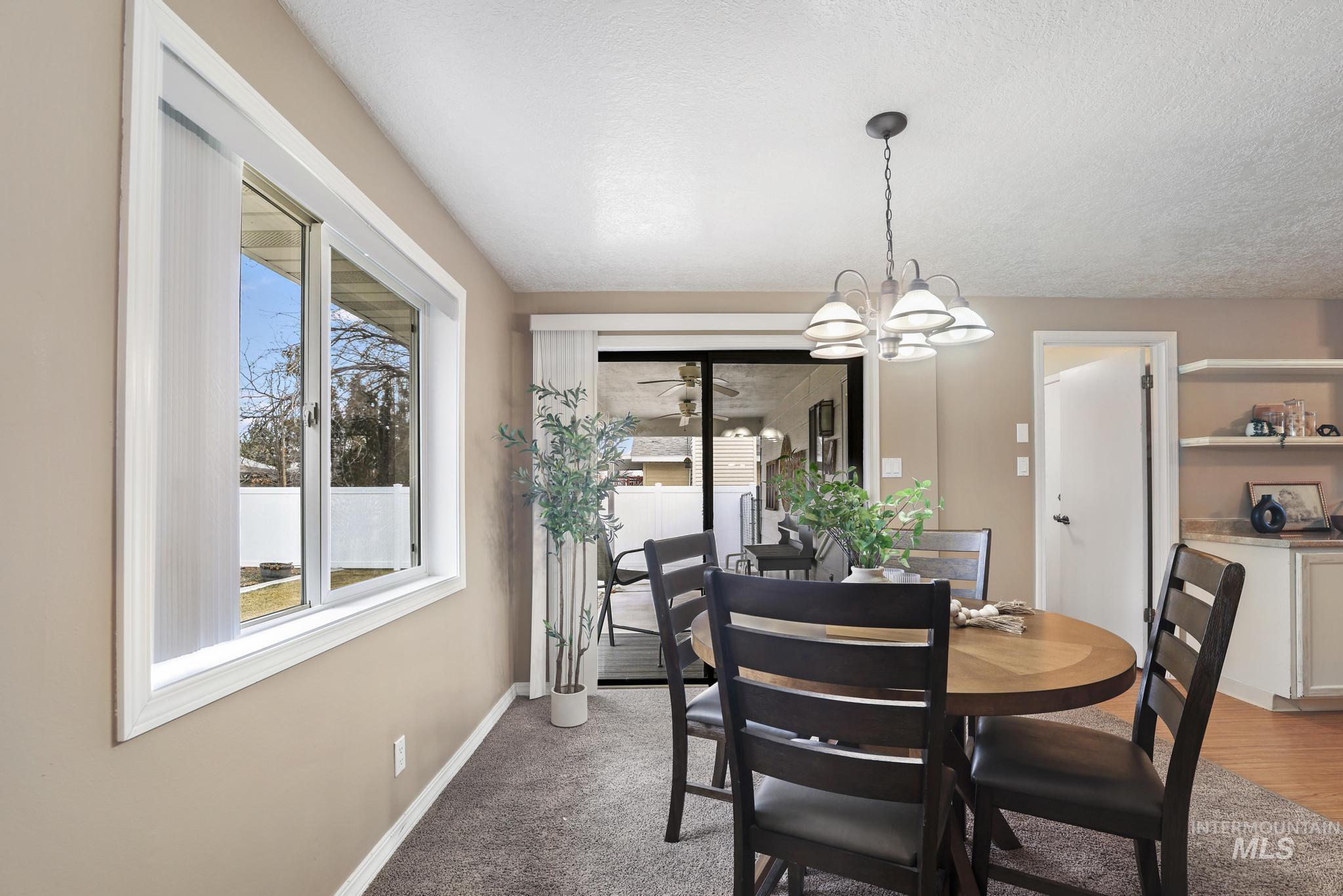 1143 Starfire Street Twin Falls, ID 83301 - Photo 13 of 32 Dining space featuring a chandelier and light colored carpet