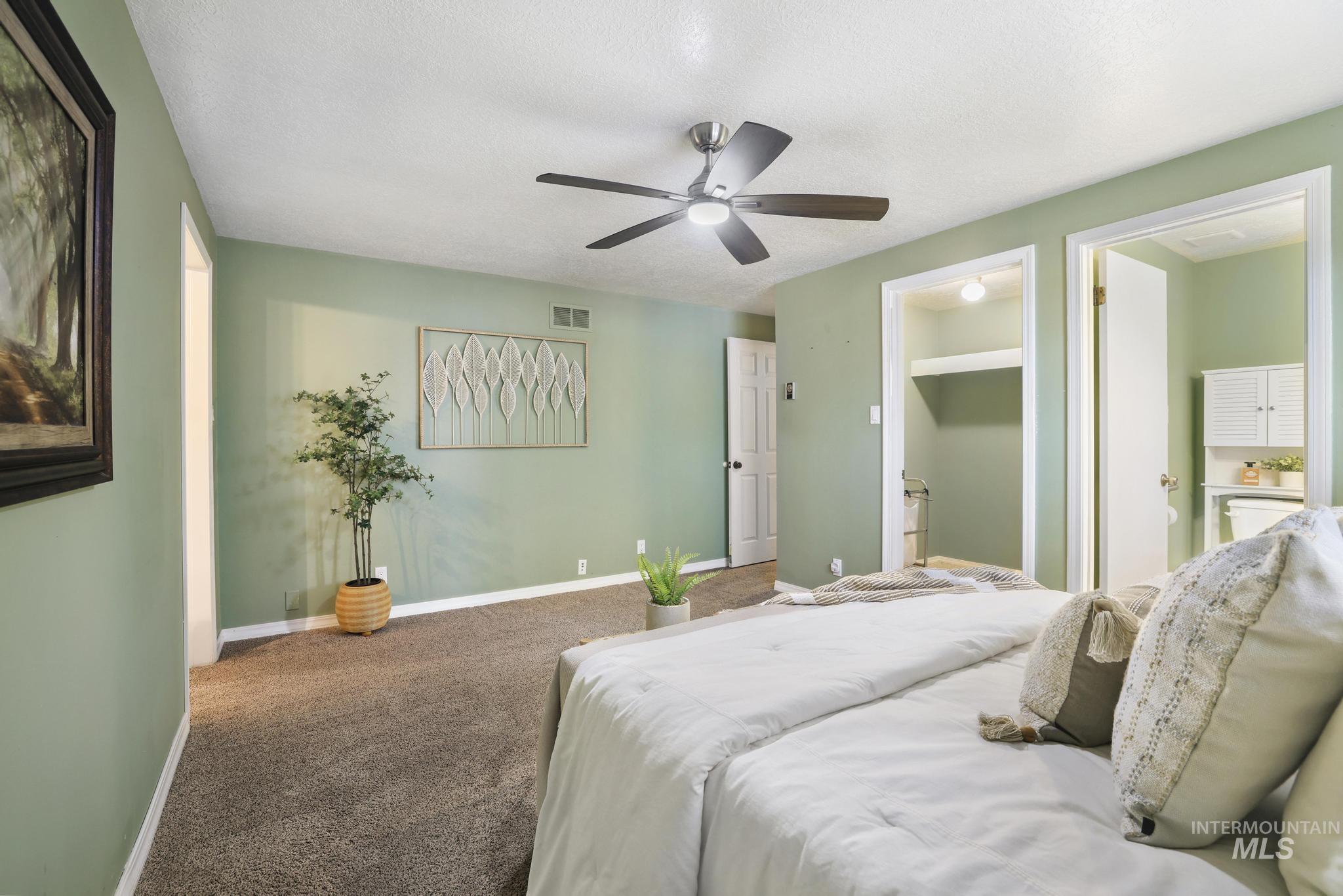1143 Starfire Street Twin Falls, ID 83301 - Photo 16 of 32 Bedroom with ensuite bath, carpet, a textured ceiling, and a ceiling fan