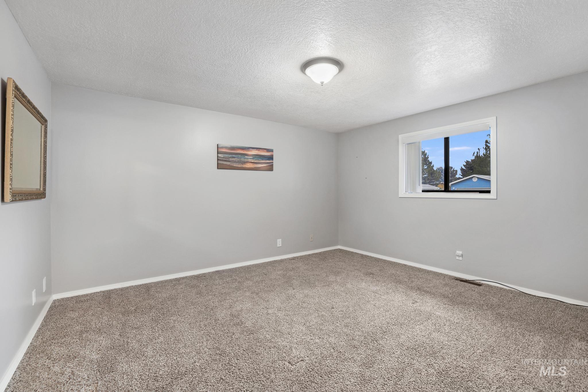 1143 Starfire Street Twin Falls, ID 83301 - Photo 20 of 32 Carpeted empty room with a textured ceiling and baseboards