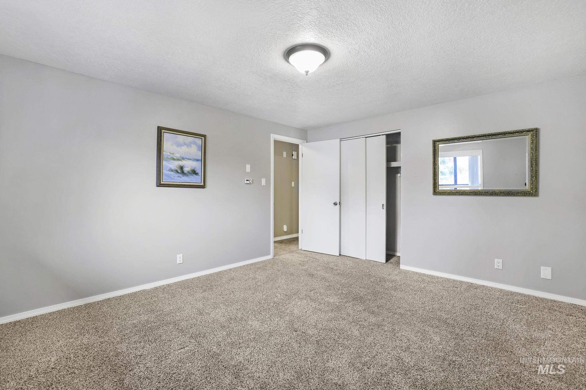 1143 Starfire Street Twin Falls, ID 83301 - Photo 21 of 32 Unfurnished bedroom featuring a textured ceiling, a closet, and carpet