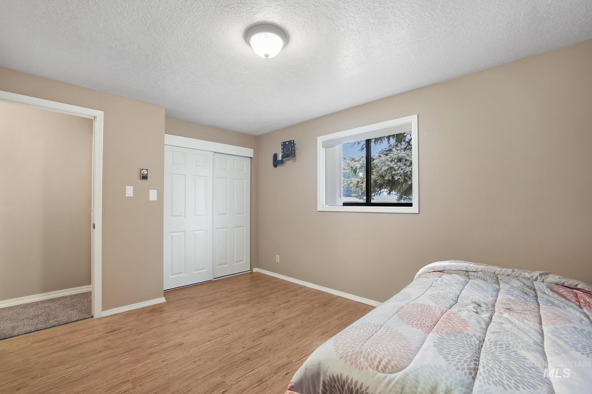 1143 Starfire Street Twin Falls, ID 83301 - Photo 25 of 32 Bedroom featuring a textured ceiling, a closet, and light wood finished floors