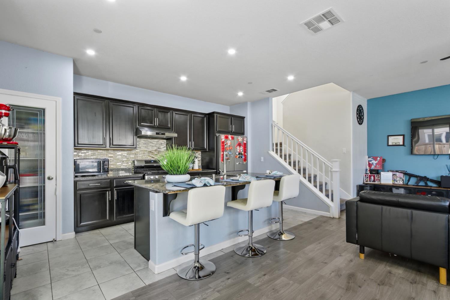 8196 Kramer Ranch Way Elk Grove, CA 95758 - Photo 12 of 47 a view of kitchen with kitchen island stainless steel appliances wooden floor dining table and chairs