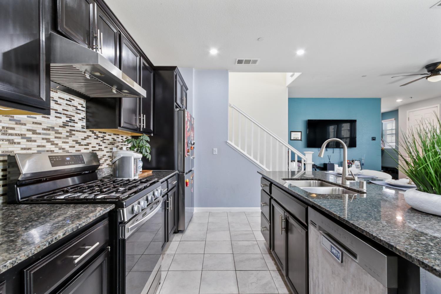 8196 Kramer Ranch Way Elk Grove, CA 95758 - Photo 15 of 47 a kitchen with stainless steel appliances granite countertop a sink stove and cabinets
