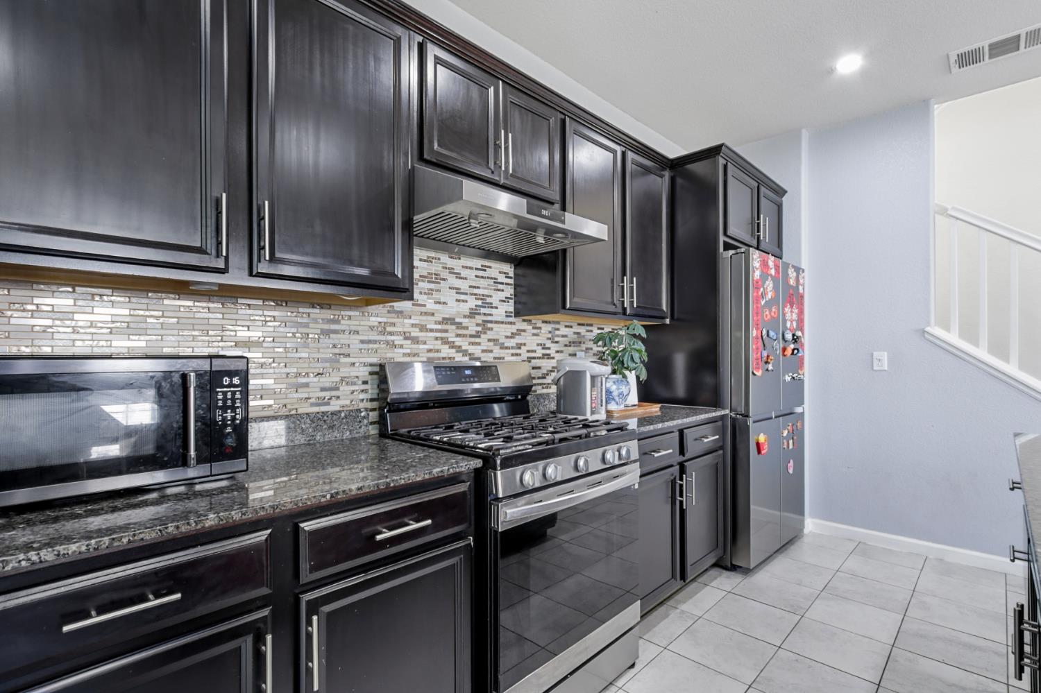 8196 Kramer Ranch Way Elk Grove, CA 95758 - Photo 16 of 47 a kitchen with stainless steel appliances granite countertop a stove and a refrigerator