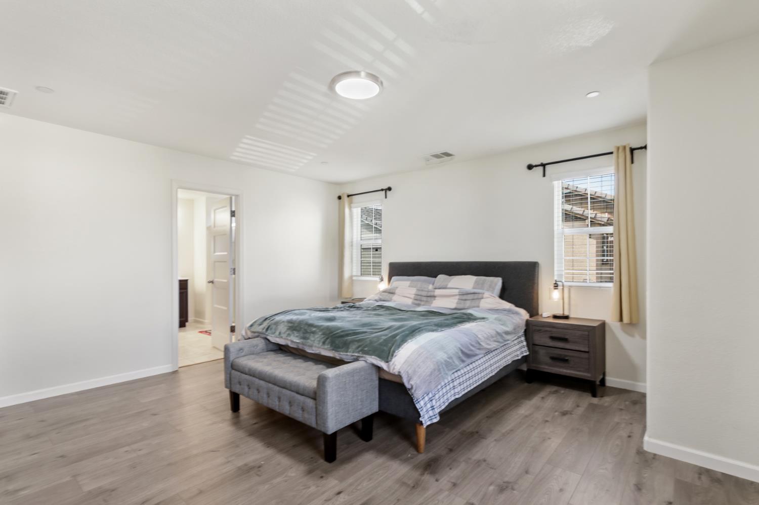 8196 Kramer Ranch Way Elk Grove, CA 95758 - Photo 23 of 47 a spacious bedroom with a bed and a wooden floor