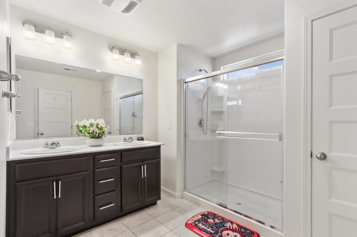 8196 Kramer Ranch Way Elk Grove, CA 95758 - Photo 25 of 47 a bathroom with a double vanity sink mirror and shower