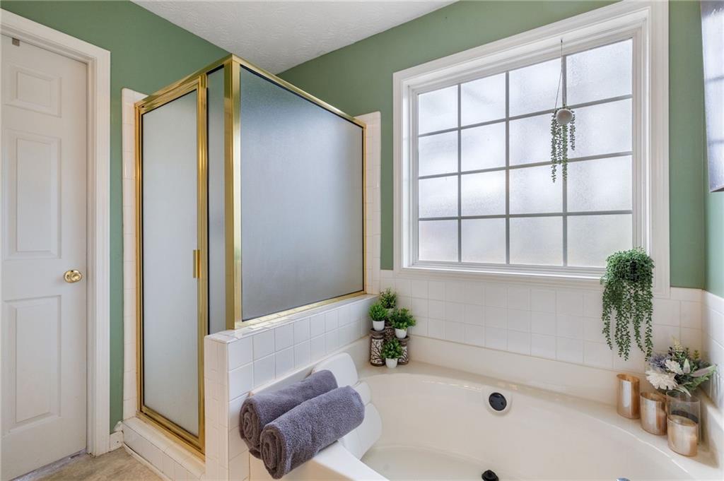 1303 Post Oak Court Winder, GA 30680 - Photo 11 of 25 a bath tub sitting in a bathroom next to a window