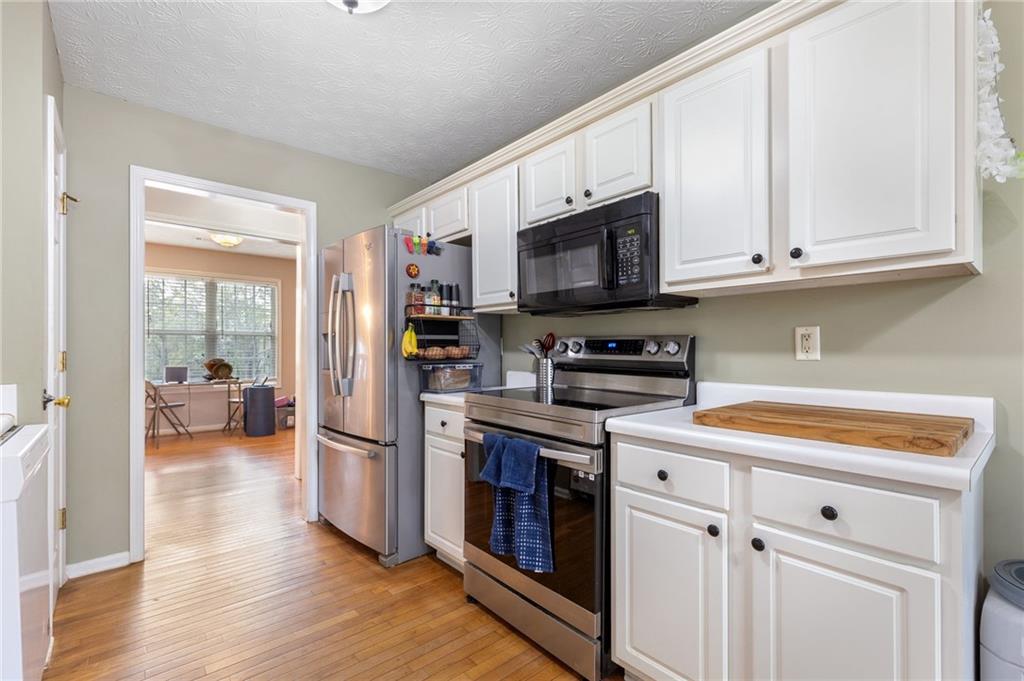 1303 Post Oak Court Winder, GA 30680 - Photo 5 of 25 a kitchen with stainless steel appliances granite countertop a refrigerator and a stove top oven