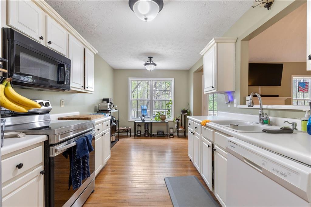 1303 Post Oak Court Winder, GA 30680 - Photo 6 of 25 a kitchen with stainless steel appliances granite countertop a stove a sink and a microwave