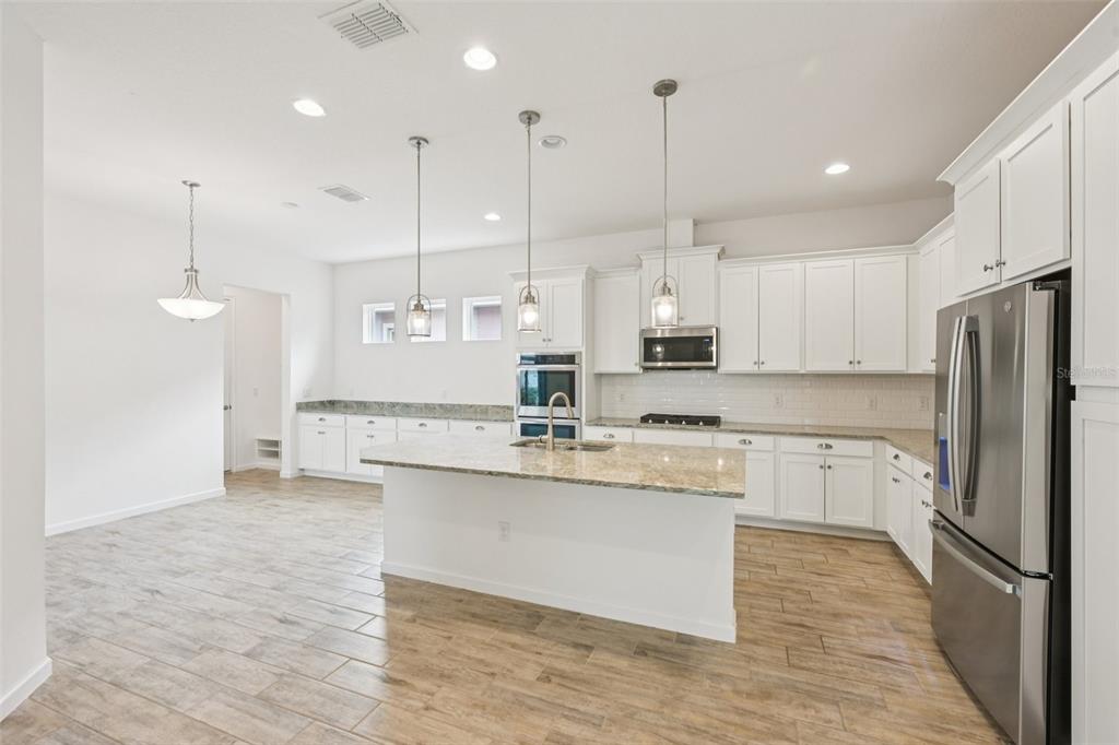 806 Winterside Drive Apollo Beach, FL 33572 - Photo 11 of 57 a kitchen with stainless steel appliances granite countertop a sink a stove a refrigerator and white cabinets