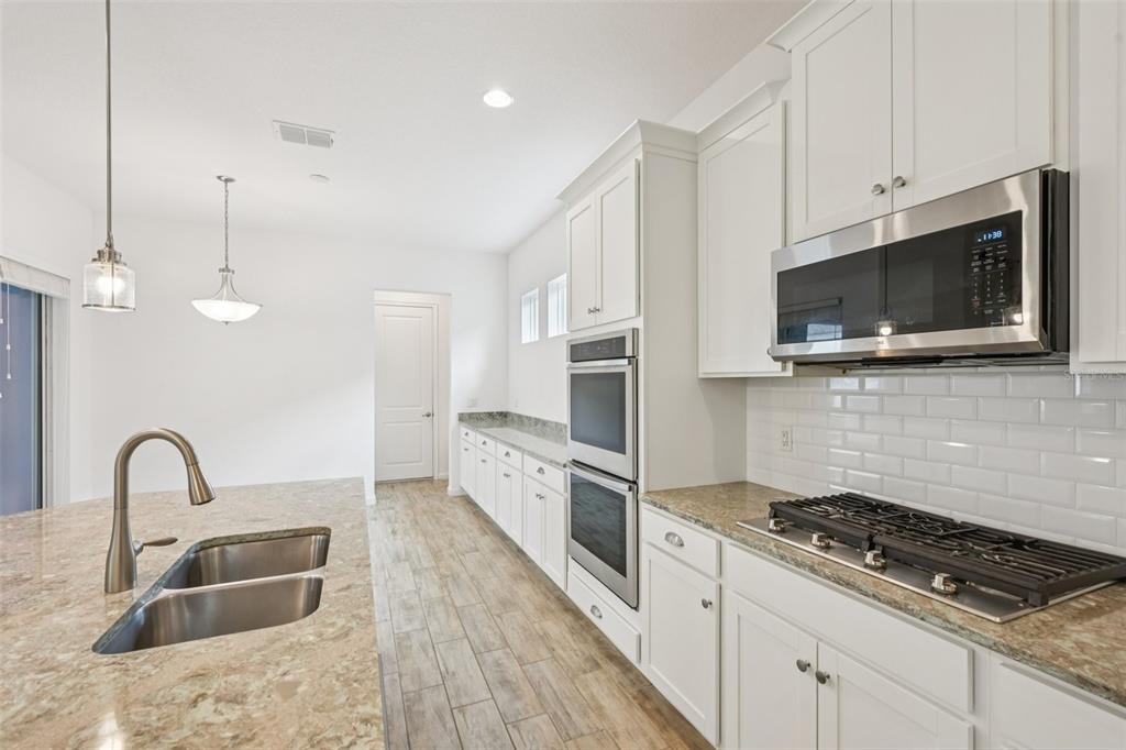 806 Winterside Drive Apollo Beach, FL 33572 - Photo 9 of 57 a kitchen with stainless steel appliances granite countertop a stove and a sink