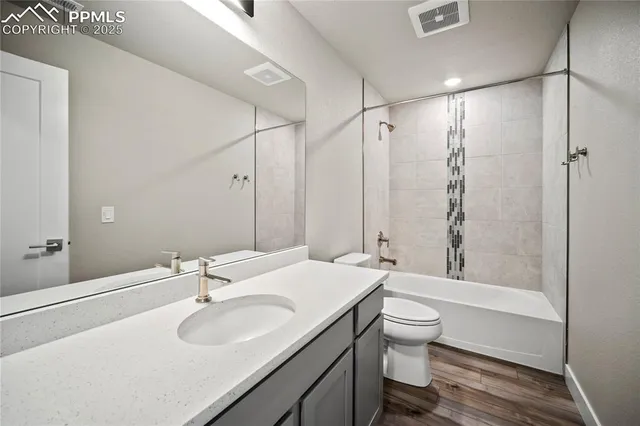 a bathroom with a granite countertop sink toilet a large mirror and shower