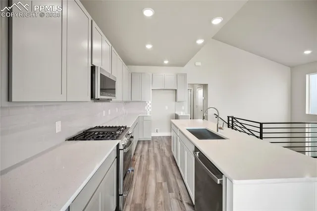 a kitchen that has a sink a stove and cabinets