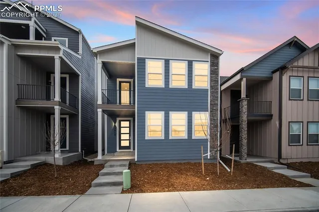 a view of yellow house with large windows