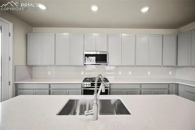 a kitchen with a sink a microwave and cabinets