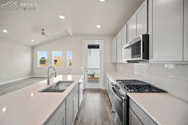 a kitchen that has a sink and a stove top oven