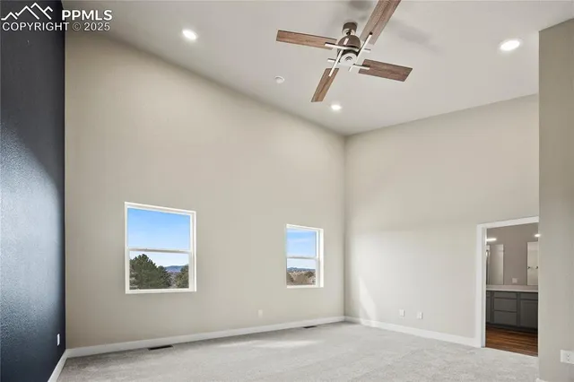 an empty room with windows and ceiling fan