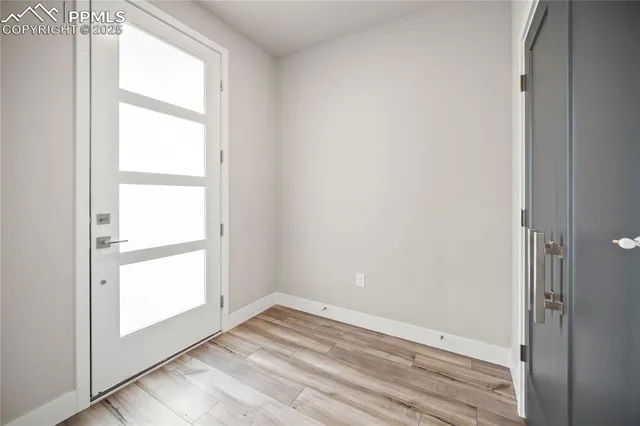 a view of empty room with wooden floor