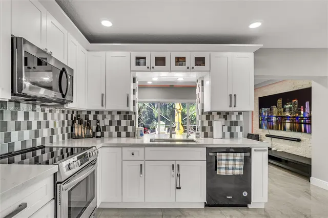 a kitchen with stainless steel appliances a sink stove and cabinets