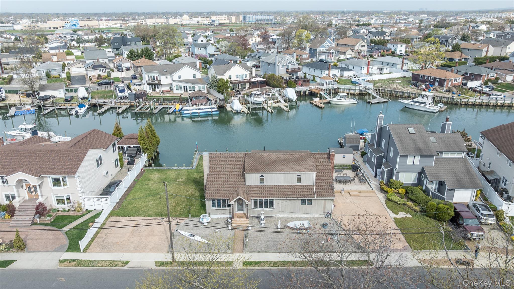 3414 Riverside Drive Oceanside, NY 11572 - Photo 25 of 25 Waterfront property featuring a private boat dock, expansive backyard with manicured lawn, and a paved driveway