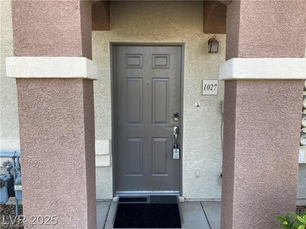 9050 West Warm Springs Road, Unit 1027 Las Vegas, NV 89148 - Photo 2 of 44 Enter through a welcoming front door, nestled between textured stucco columns, presenting a neat and accessible entry.