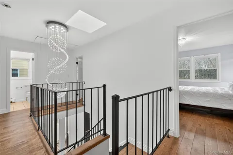 a view of staircase with wooden floor and a chandelier