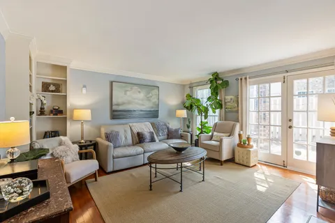 a kitchen with white cabinets appliances a sink and a window