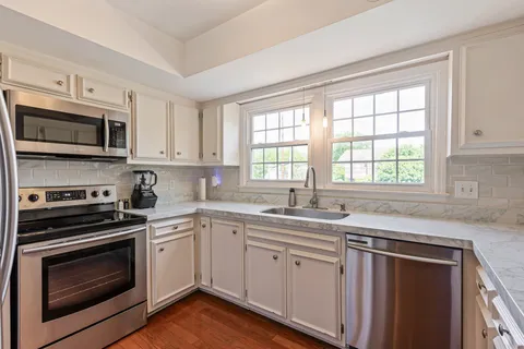 a kitchen with stainless steel appliances white cabinets and a stove