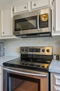 a kitchen with stainless steel appliances granite countertop white cabinets and a sink