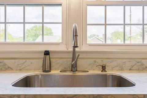a bedroom with a bed table plant and a window