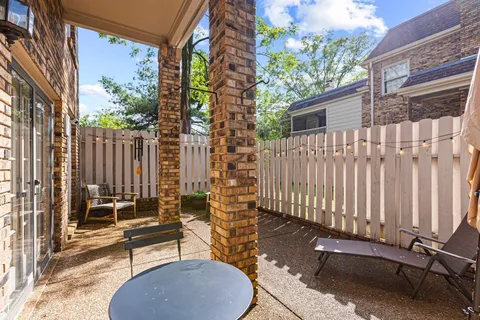 a view of a brick house with a bench next to a road