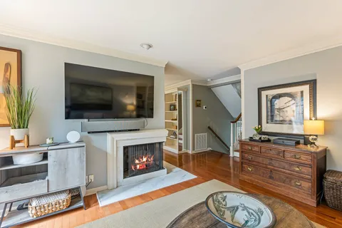 a living room with furniture a flat screen tv and a fireplace