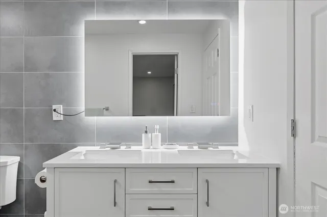 a bathroom with a granite countertop sink and a mirror