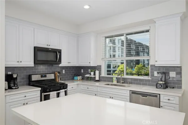 a kitchen with stainless steel appliances a stove sink microwave and cabinets