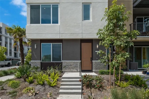 a front view of a house with plants
