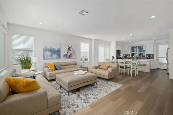a living room with furniture and view of kitchen
