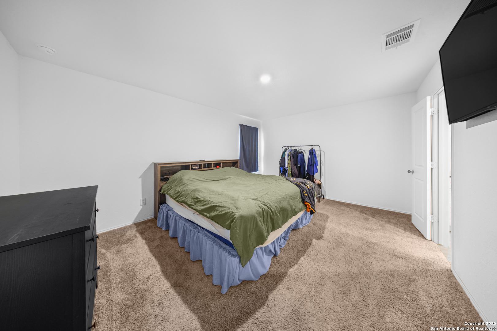 5424 Thyme Corner St. Hedwig, TX 78152 - Photo 17 of 21 a bedroom with a bed and flat screen tv