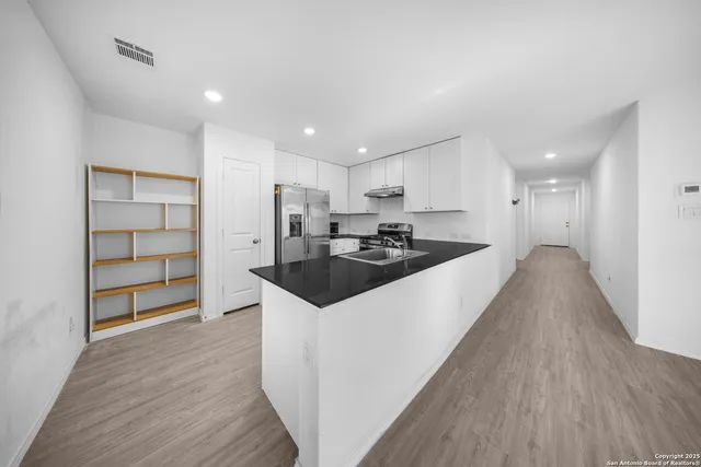 a kitchen with granite countertop a sink and cabinets